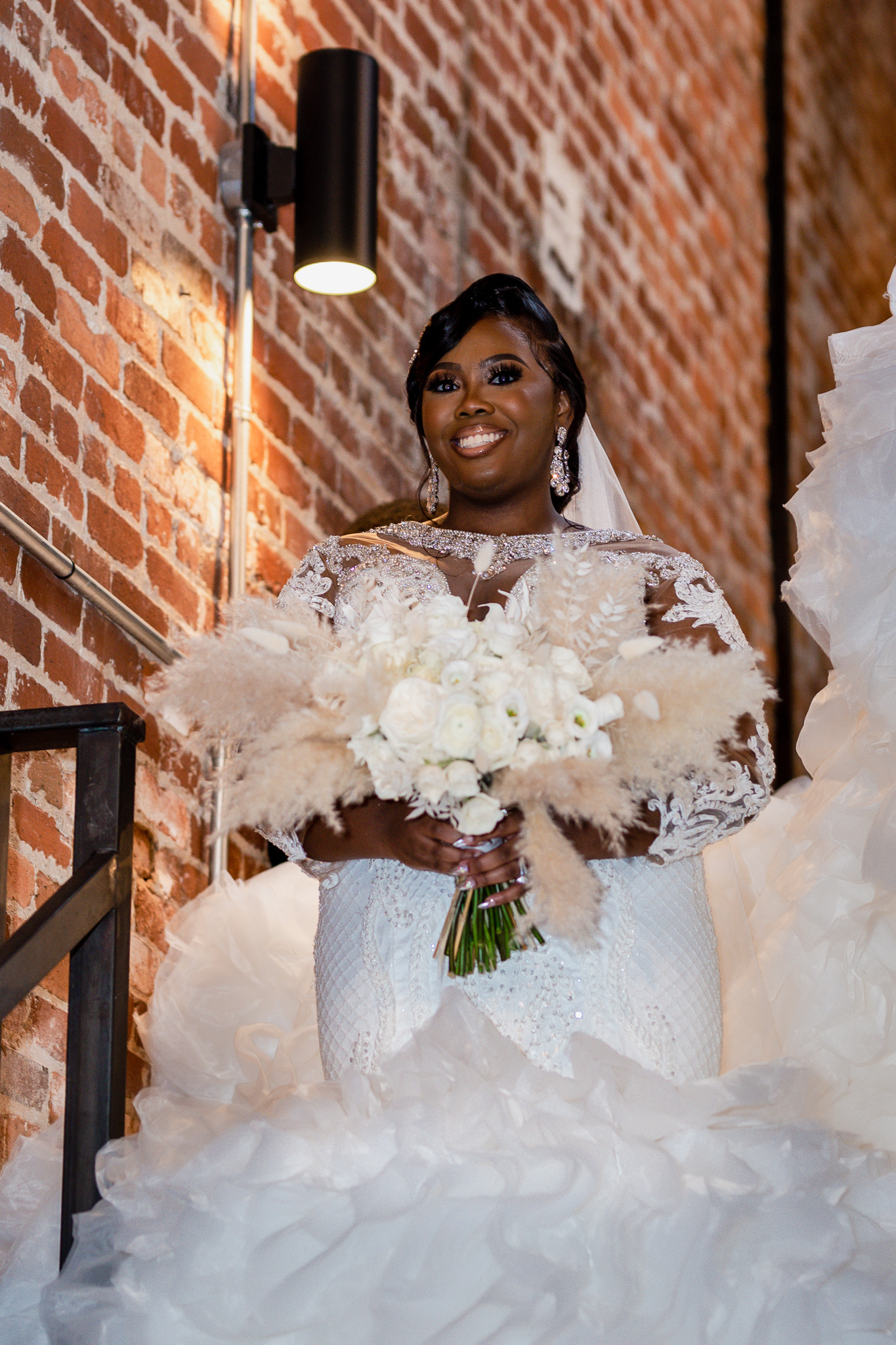 Stunning Boho Bride holding boutique in hand, with a huge smile on her face!