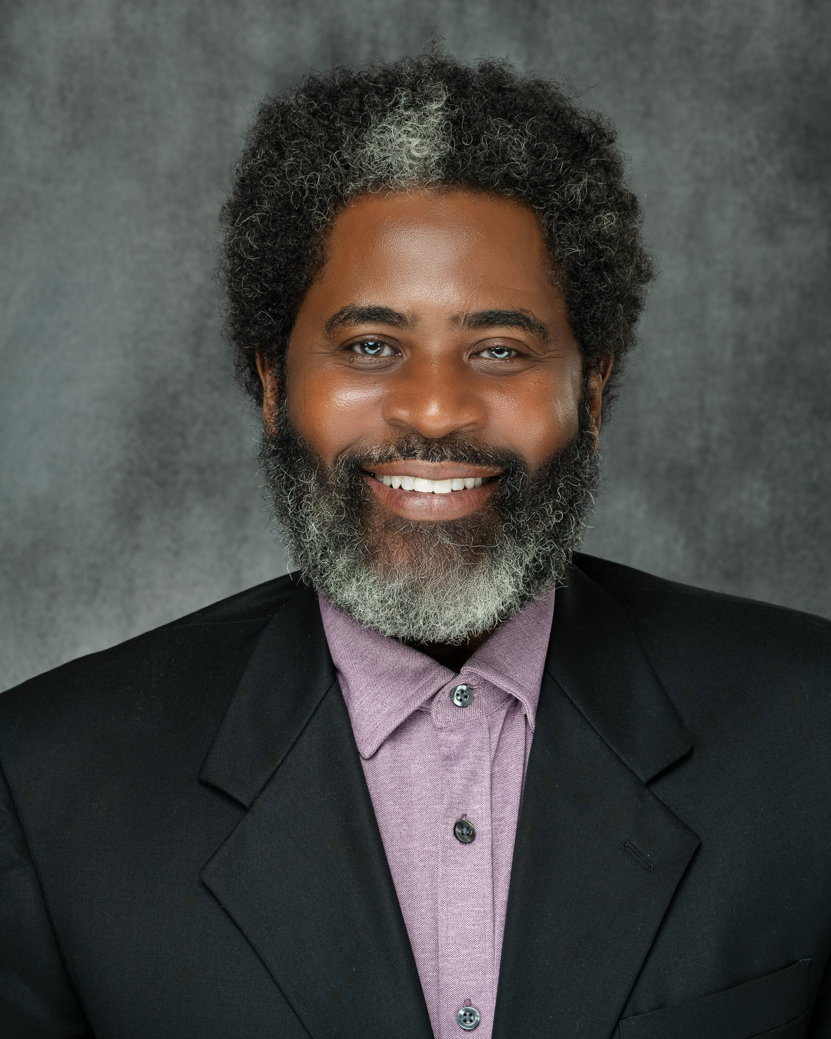 Professional Business Headshot of a man smiling, in a black suit, taken by PWG Lens - Atlanta Headshot Photographer.
